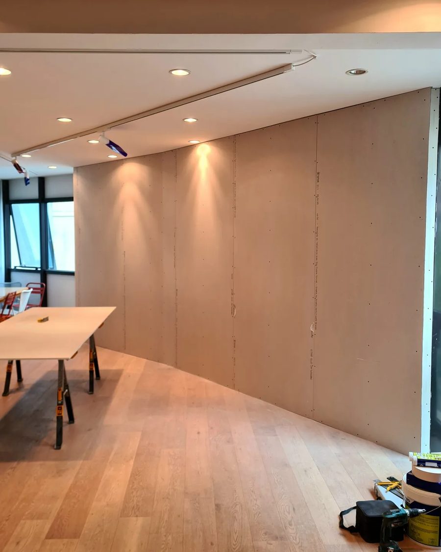 Doublage courbe en plaques de plâtre et faux plafond avec spots dans un local professionnel
