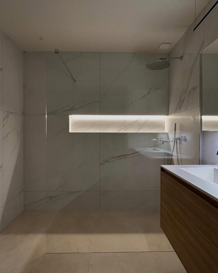 Salle de bains rénovée : plafond, doublages et niche réalisés par Primoplac, carrelage grand format et douche à l'italienne