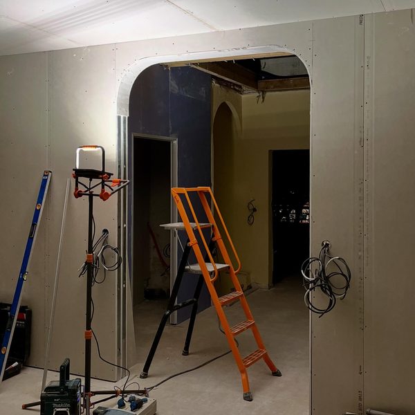 Ouverture cintrée en plaques de plâtre en cours de montage dans un appartement, chantier de nuit