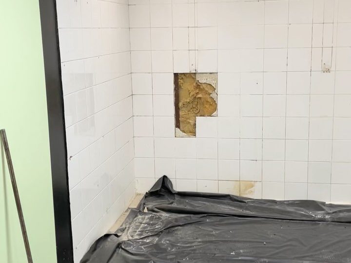 Anciennes douches carrelées d'un vestiaire collectif avant les travaux, carrelage abîmé