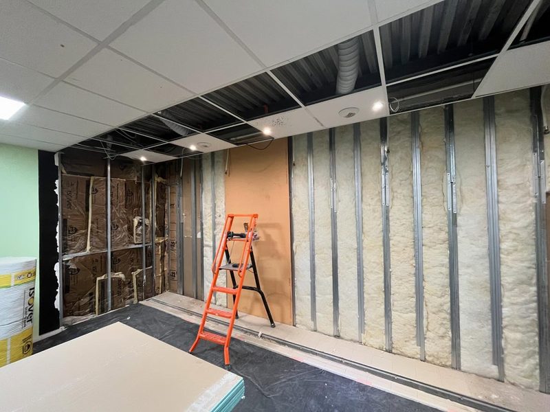 Ossature métallique et laine de verre posées sur les murs existants du vestiaire, plafond démontable ouvert